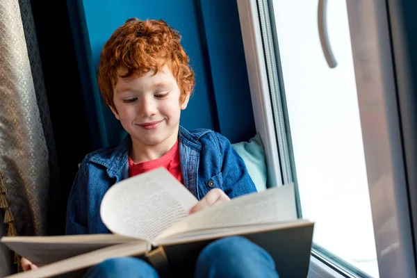 Мило Улыбаясь Маленький Мальчик Чтение Книги Сидя Подоконнике — стоковое фото