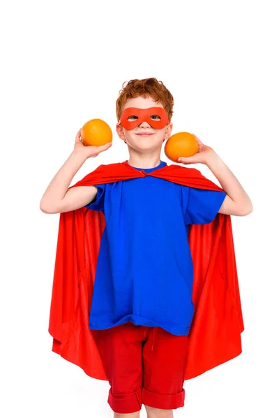 Счастливый Ребенок Костюм Супергероя Холдинг Апельсины Улыбаясь Камеру Изолированные Белом — стоковое фото
