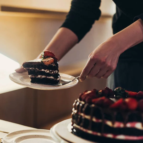 Женщина, положить кусок торта на плите — стоковое фото