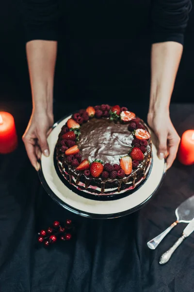 Женщина положить торт стоять на столе — стоковое фото
