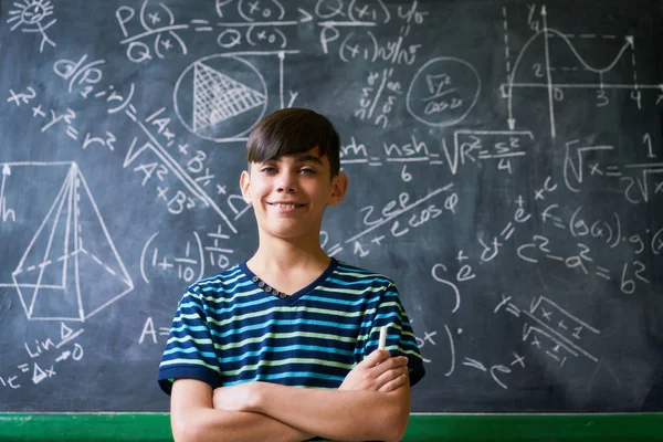 Уверенно Latino мальчик улыбается на камеру во время урока математики — стоковое фото