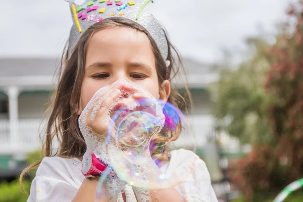 Счастливый ребенок, играя с мыльных пузырей — стоковое фото