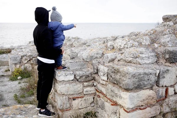 Отец с маленьким мальчиком, стоя в руинах — стоковое фото