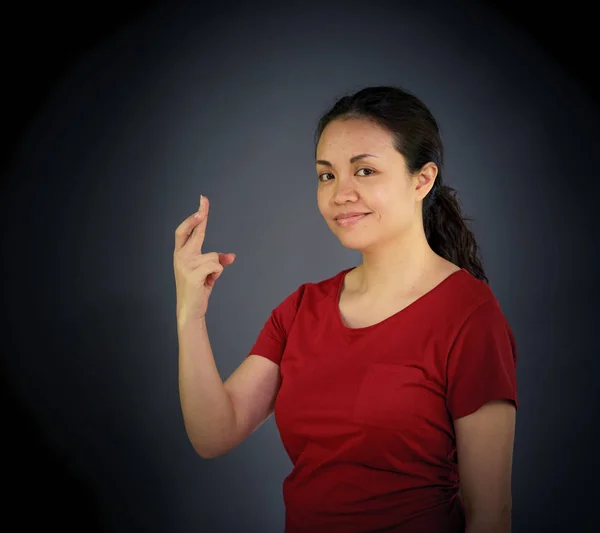 Женщина смотрит в камеру с пальцы пересекли — стоковое фото