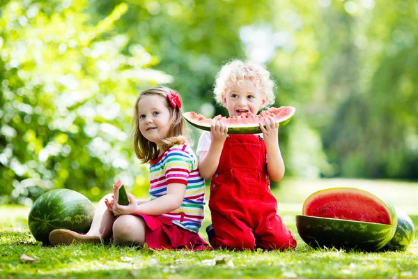 Дети едят арбуз в саду — стоковое фото