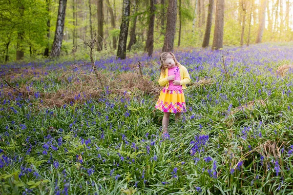 Ребенок с колокольчика цветы в лесу весной — стоковое фото