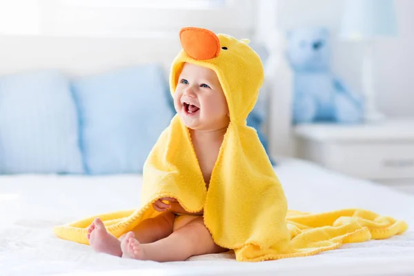 Милый ребенок после ванны в полотенце желтая утка — стоковое фото