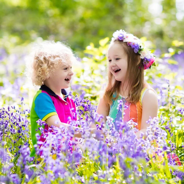Дети с цветами колокольчика, садовый инвентарь — стоковое фото
