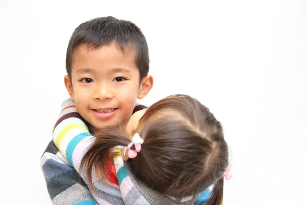 Japanese brother and sister hugging each other (7 years old boy and 2 years old girl) — стоковое фото