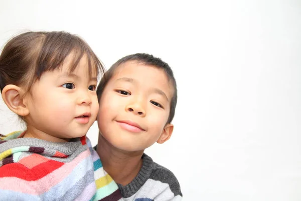 Japanese brother and sister hugging each other (7 years old boy and 2 years old girl) — стоковое фото