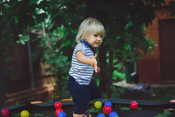 Мальчик, прыжки на батуте с цветными шариками — стоковое фото