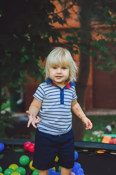 Мальчик, прыжки на батуте с цветными шариками — стоковое фото