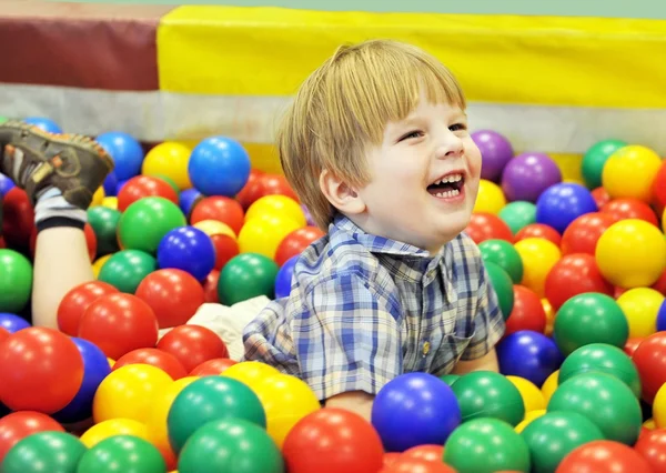 Счастливый малыш, играя с цветными шариками — стоковое фото