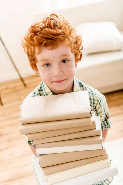 Маленький мальчик и куча книг — стоковое фото
