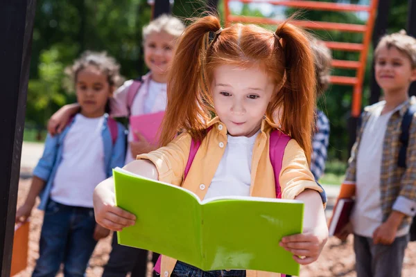 Ребенок с книгой на площадке — стоковое фото