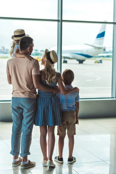 Семья, глядя из окна в аэропорту — стоковое фото