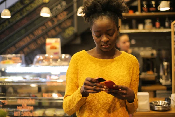 Young Afro Woman Bistro Putting Away Her Credit Card — стоковое фото