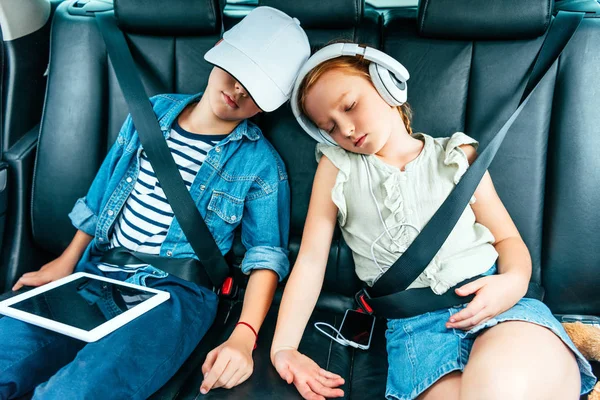Exhausted Children Digital Devices Sleeping Car Trip — стоковое фото