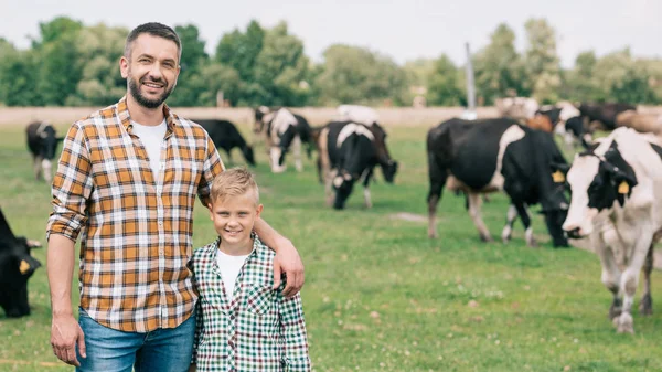 Happy Father Son Smiling Camera While Standing Grazing Cattle Farm — стоковое фото