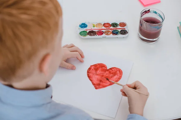 Partial View Preschooler Red Hair Boy Drawing Heart Paper Table — стоковое фото