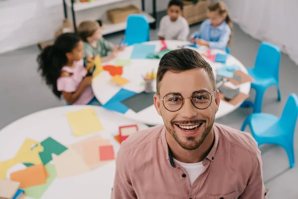 Selective Focus Smiling Teacher Eyeglasses Interracial Kids Table Classroom — стоковое фото