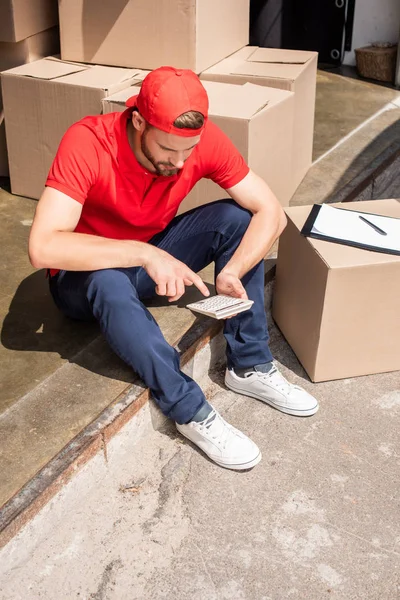 High Angle View Young Delivery Man Making Calculations Calculator Cardboard — стоковое фото