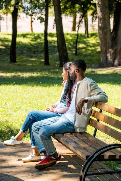 African American Couple Sitting Wooden Bench Park Looking Away — стоковое фото