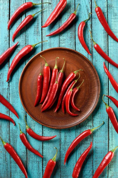 Top View Red Ripe Chili Peppers Plate Blue Wooden Table — стоковое фото