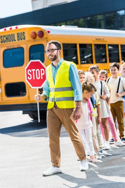 Traffic Guard Crossing Road Happy Pupils Front School Bus — стоковое фото
