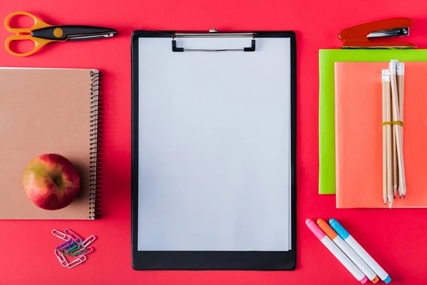 Top View Empty Clipboard Apple Arranged Variety Stationery Red Background — стоковое фото