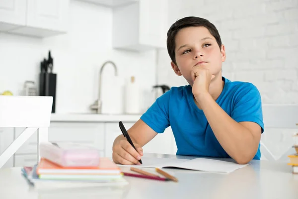 Portrait Thoughtful Boy Doing Homework Alone Table Home — стоковое фото