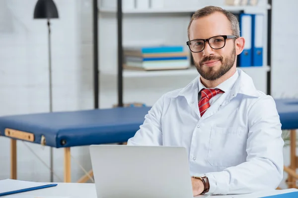 Portrait Smiling Male Chiropractor White Coat Workplace Laptop Hospital — стоковое фото