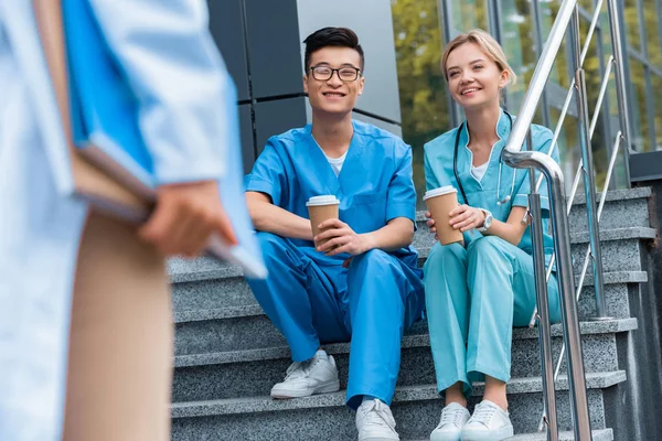 Cropped Image Teacher Looking Smiling Medical Students Sitting Stairs Coffee — стоковое фото