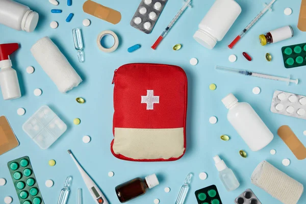 Top View Red First Aid Kit Bag Blue Surface Surrounded — стоковое фото