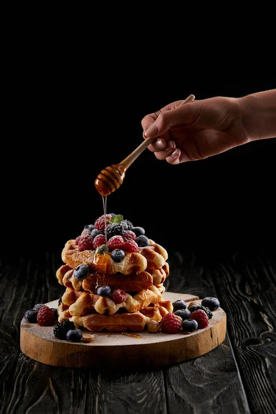 Cropped Shot Woman Pouring Honey Stack Belgian Waffles Black Wooden — стоковое фото