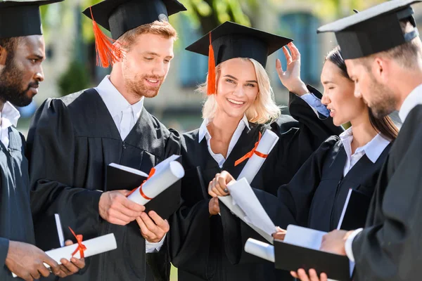 Smiling Multiethnic Graduated Students Capes Diplomas — стоковое фото