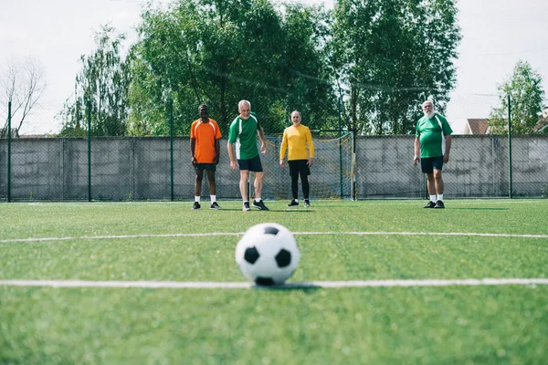 Selective Focus Football Ball Multicultural Elderly Men Green Football Field — стоковое фото