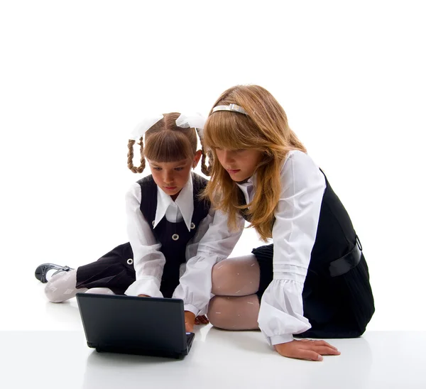 Школьницы в форме с ноутбуком — стоковое фото