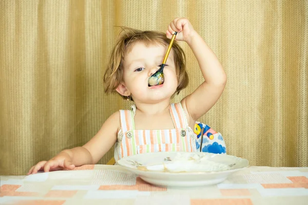 Маленькая девочка ест кашу — стоковое фото