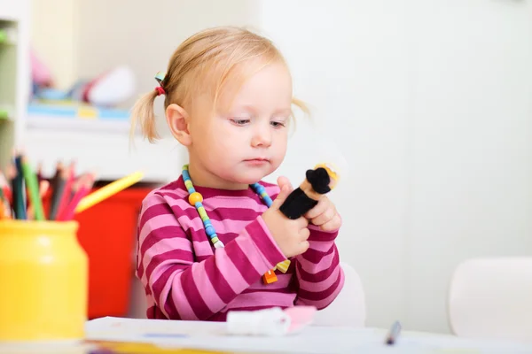 Малыш девушка играет с куклами палец — стоковое фото