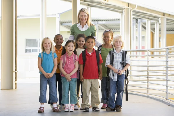 Воспитатель детского сада, стоя с детьми в коридоре — стоковое фото