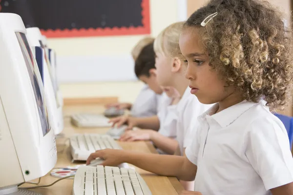 Девушка работает на компьютере в начальной школе — стоковое фото