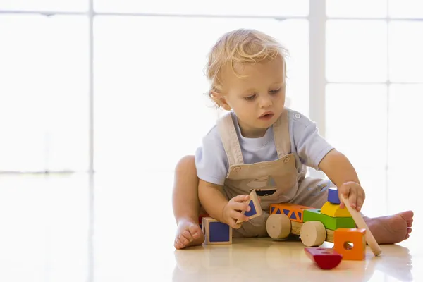 Ребёнок в помещении играть с игрушка грузовик — стоковое фото