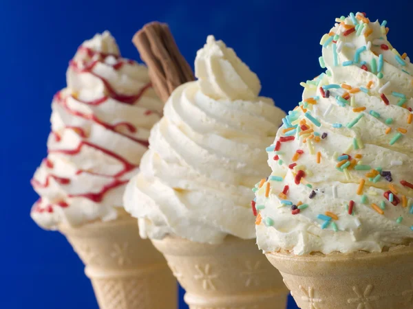 Взбитые конусы мороженого с тремя разными начинками — стоковое фото