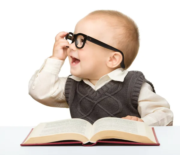 Маленький ребенок играть с книгой и очки — стоковое фото