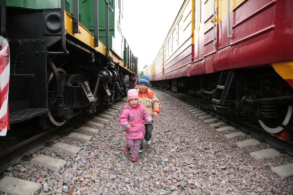 Двое детей между поездами — стоковое фото