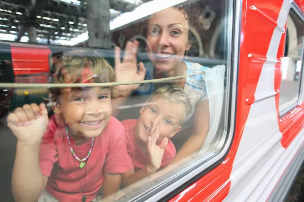 Матери и дети выглядят из окон поезда — стоковое фото