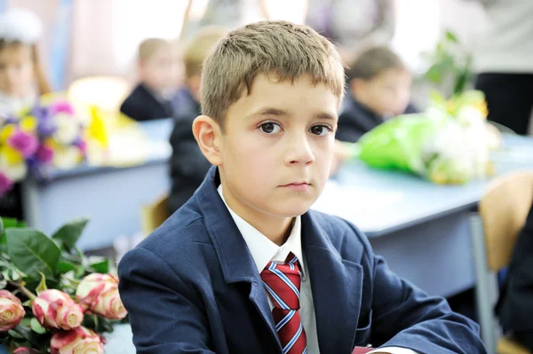 Портрет первоклассника мальчик сидел на своем столе — стоковое фото
