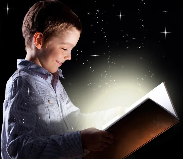 Мальчик открыл волшебную книгу — стоковое фото