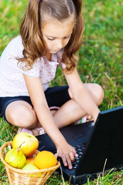 Портрет девушки (для ребенка) с ноутбуком и фрукты — стоковое фото